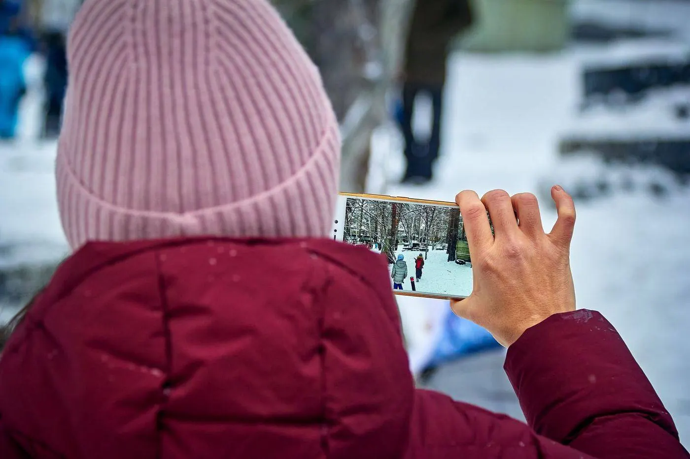 Homeowner photographing storm-damaged roof shingles with a smartphone for insurance documentation